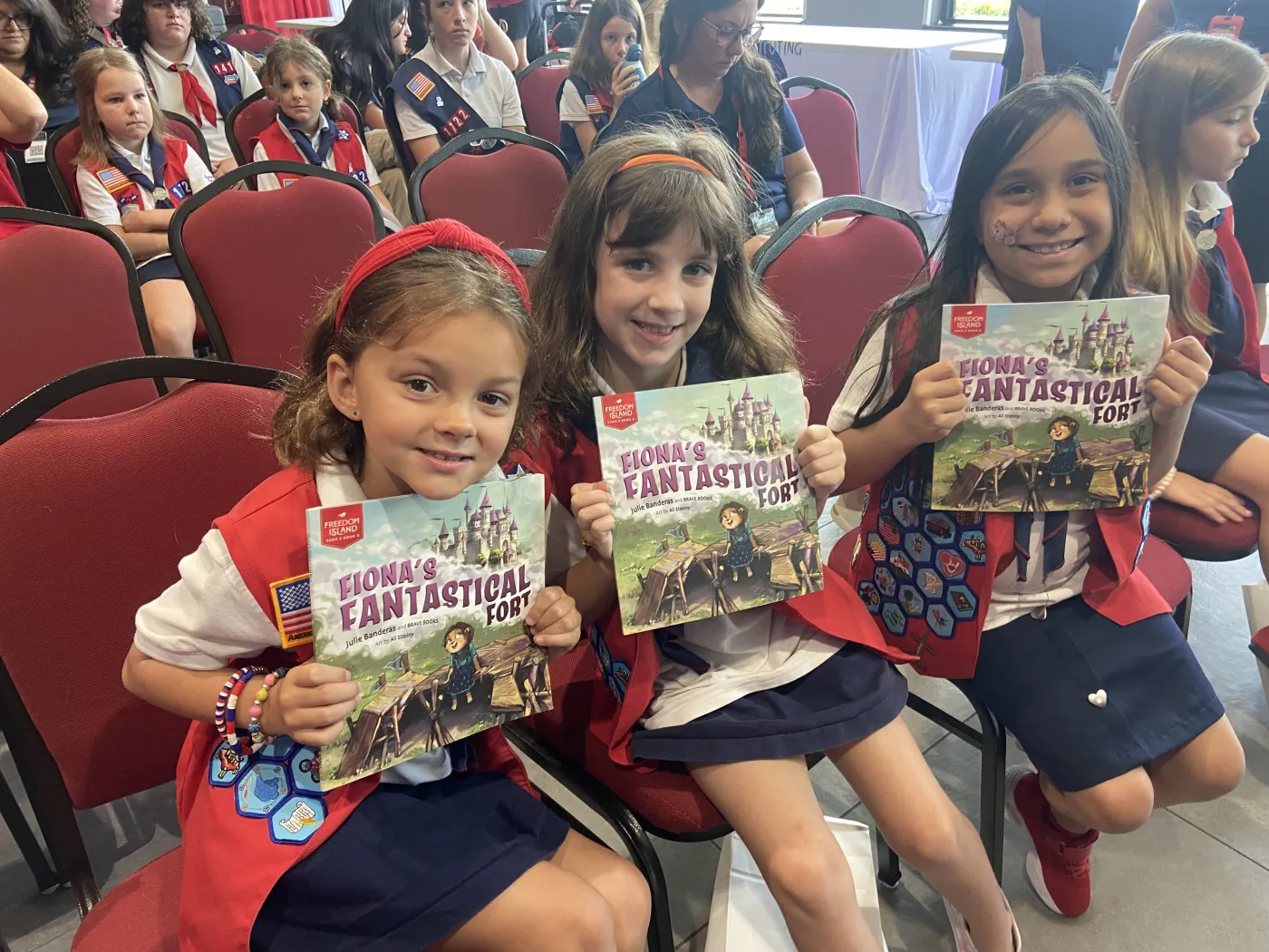 Three girls holding their donated copies of a BRAVE Books title